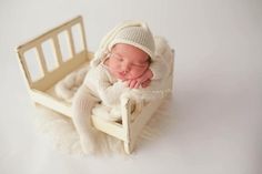 a newborn baby is sleeping on a white chair