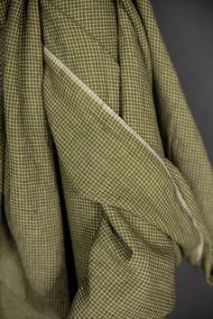 the back of a green and white checkered jacket with buttons on it's lapel