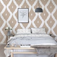 a bed sitting in a bedroom next to a wall with a white and gray pattern on it