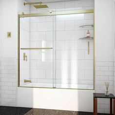 a bathroom with a white tiled floor and a gold framed glass shower door that is open