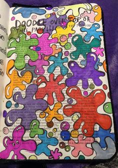 an open book with lots of different colored shapes and words on the pages, in front of a purple background