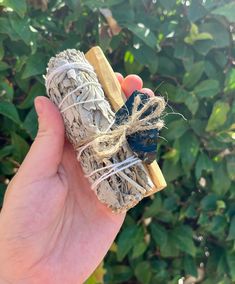 a hand holding an item made out of wood and rope