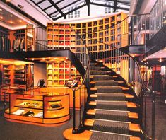 the inside of a library with stairs and bookshelves