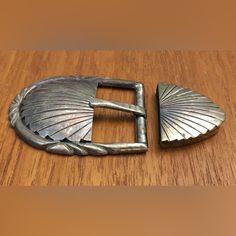 a metal belt buckle sitting on top of a wooden table