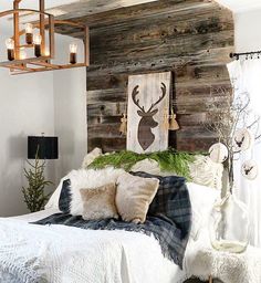 an instagramted photo of a bed with deer head on the wall above it