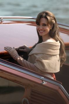 a woman sitting in the driver's seat of a boat