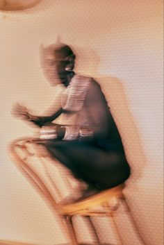 a man sitting on top of a wooden chair