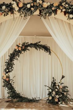 a wedding arch decorated with flowers and greenery