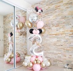 a balloon decorated with minnie mouse numbers and balloons is displayed in front of a mirror