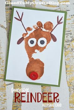 a reindeer handprinted on a white card with red nose and brown antlers