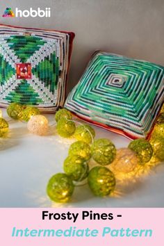 two green and white bags sitting next to each other on top of a table with string lights