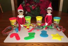 the elf on the shelf is playing with play - doh and other toys in front of him