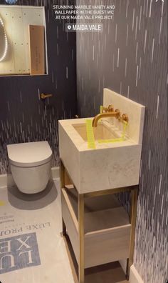 a white toilet sitting next to a sink in a bathroom under a shower curtain with yellow tape on it