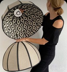 a woman is holding two large hats