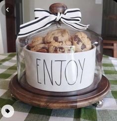 a glass container filled with cookies on top of a table