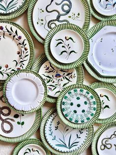 many plates with designs on them are arranged in a pattern and one is green, the other white