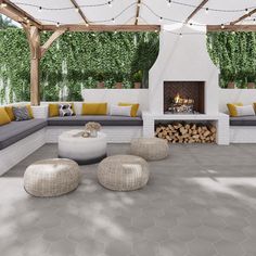 an outdoor living area with fireplace, couches and firewood stacked on the floor