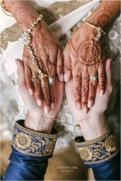 two hands with henna tattoos on them