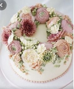 a white cake with pink and green flowers on it