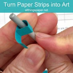 a person holding a piece of blue paper with the words turn paper strips into art