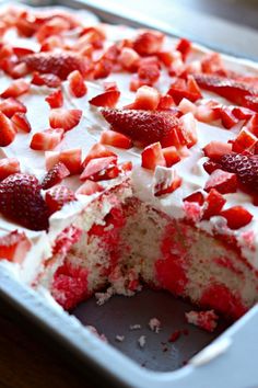 a cake that has been cut into pieces and is sitting on a pan with strawberries