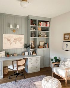 a home office with gray painted walls and white furniture, along with a map on the wall