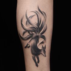 a black and white photo of a woman's leg with a tattoo design on it