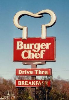 a burger chef restaurant sign in the middle of a parking lot with cars parked nearby