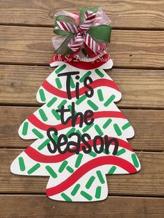 a paper cut out christmas tree with the words tie the season on it and a bow