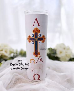 a white cup with a cross on it