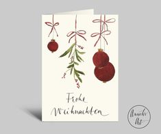 a christmas card with two ornaments hanging from it