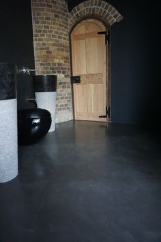 two black trash cans sitting in front of a wooden door