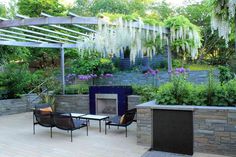 an outdoor living area with chairs, tables and a fire place in the middle of it