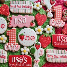 decorated cookies are arranged in the shape of letters and numbers on a green surface with pink, red, and white accents