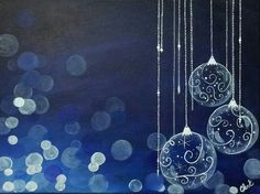 three glass ornaments hanging from strings on a blue and black background with boket lights