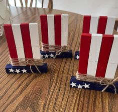 three red, white and blue wooden blocks tied with twine on top of a table