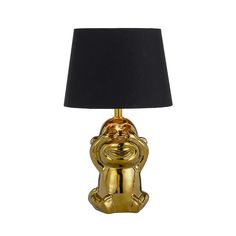 a gold monkey lamp with a black shade