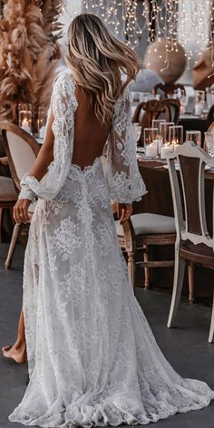 a woman in a white wedding dress standing next to a table