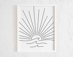 a black and white print with the sun in the middle on a wall above it