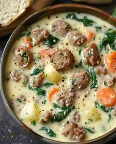 a bowl of soup with meat, carrots and spinach in it next to bread