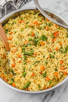 a pan filled with rice and vegetables on top of a table