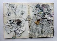 an open book with torn paper and other things on the pages that have been altered to look like art