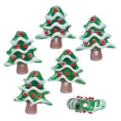 small christmas trees with red berries and white frosting on them, sitting next to each other