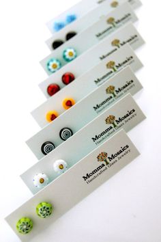 five business cards with different designs and colors are lined up on a white table top