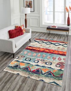 a living room filled with furniture and a rug on top of a hard wood floor