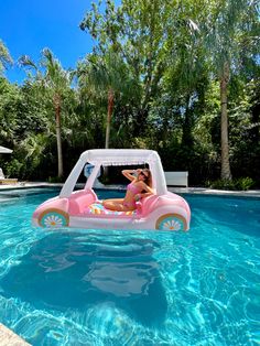 a woman in a pink car floating on top of a pool