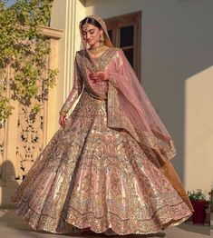 a woman in a pink and gold wedding gown