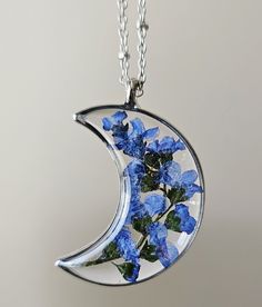 "This stunning Forget me not flower necklace is encapsulated in resin Moon open bezel.  The pendant is 0.60\" wide x 1.75\" high x 1/8\" thickness and come with a beautiful chain-length of your choice. The petals have been carefully preserved to retain their color and would make a great gift for your loved ones. This piece was made with real flowers and hence it is important to preserve the jewelry in the box provided safely away from direct sunlight.  You can see more of my Handmade Items here:  https://www.etsy.com/shop/Thecraftiechristie" Nature-inspired Resin Birth Flower Jewelry, Nature-inspired Birth Flower Resin Jewelry, Blue Flower Resin Jewelry, Unique Resin Flower Jewelry, Pressed Flowers Resin Jewelry As A Gift, Unique Flower-shaped Resin Jewelry, Resin Flower Jewelry With Flower Charm, Flower-shaped Resin Jewelry Gift, Unique Pressed Flower Jewelry