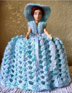 the doll is wearing a blue crocheted dress