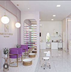 the interior of a nail salon with purple chairs